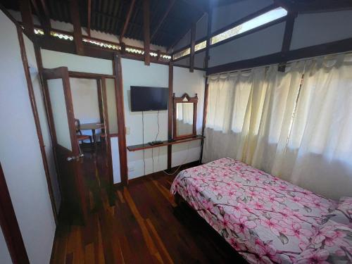 a bedroom with a bed and a tv in it at Hostería El Sendero - Cocorná in Cocorná