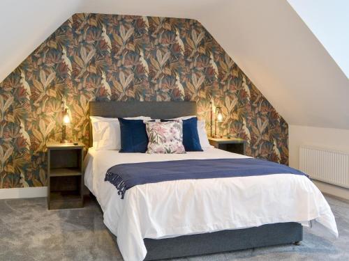 a bedroom with a large bed with a floral wallpaper at West Lodge in Sewerby