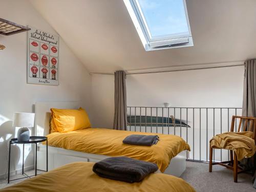 a bedroom with two beds and a window at The Old Workshop in Appledore