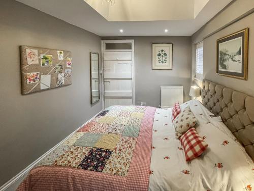 1 dormitorio con 1 cama con edredón en Acorn Cottage en Linton