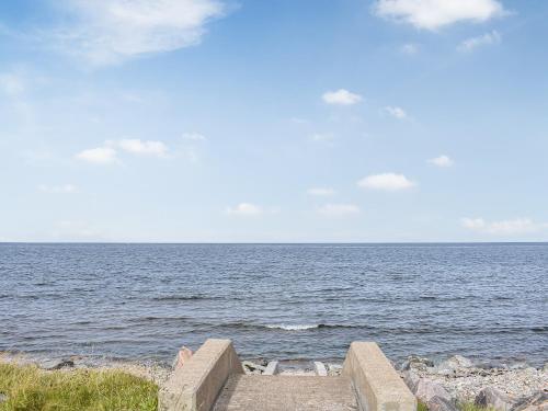 a stone stairway leading to the ocean on a beach at Braeside Cottage in Buckie