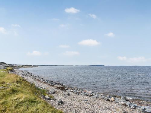 a rocky shoreline with the ocean in the background at Braeside Cottage in Buckie