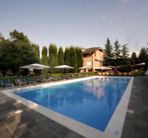 a large swimming pool with chairs and umbrellas at Il Cascinalenuovo in Asti