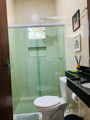 a bathroom with a toilet and a glass shower at Portuá Chalés in São Miguel dos Milagres