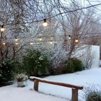 a wooden bench sitting in the snow with lights at Hotel Kelman in Perito Moreno