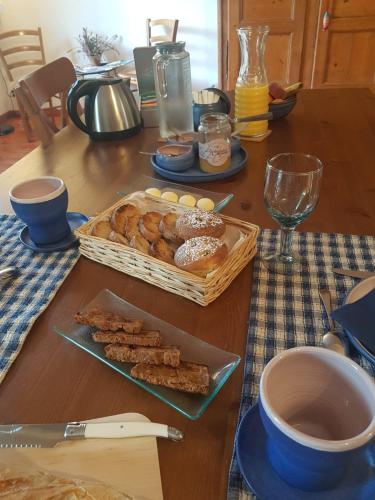 ein Tisch mit einem Tablett mit Gebäck und einem Korb mit Donuts in der Unterkunft Le mas des Landes in Vielle-Saint-Girons