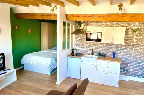 eine Küche mit einem Bett und einem Waschbecken in einem Zimmer in der Unterkunft Rétro chic au coeur de Villeurbanne in Villeurbanne