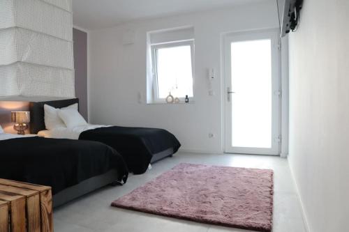 a bedroom with two beds and a pink rug at RheinMosel Glück 12 in Koblenz