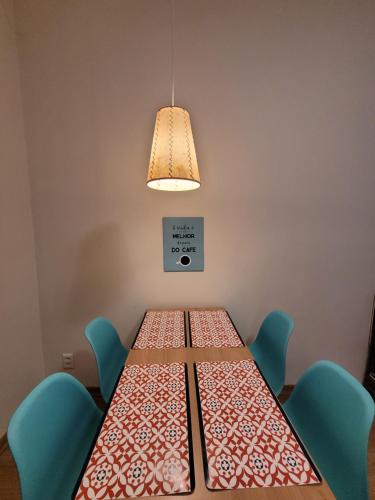 een tafel met vier stoelen en een lamp bij Apê Turquesa, 190 m da praia do Leme in Rio de Janeiro