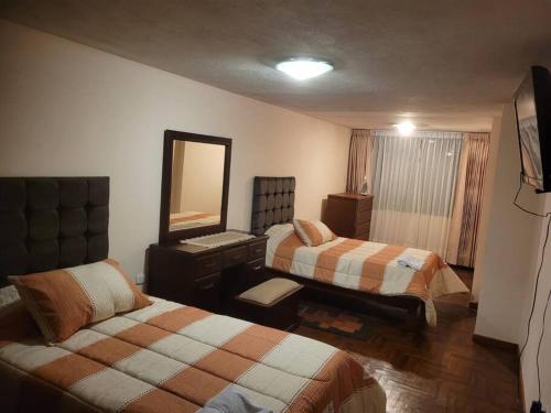 a hotel room with two beds and a mirror at Amplio y lindo departamento. in Arequipa