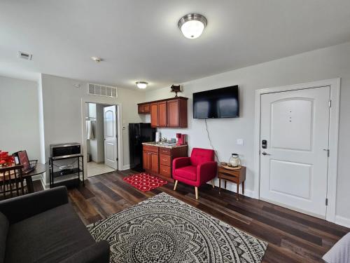 a living room with a couch and a red chair at Memorable Stay at The Inman - 216 in Champaign