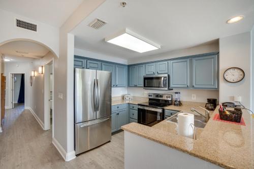 a kitchen with blue cabinets and a stainless steel refrigerator at 1 Mi to Disney World Lakefront Condo in Orlando! in Orlando