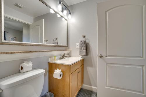 a bathroom with a toilet and a sink and a mirror at 1 Mi to Disney World Lakefront Condo in Orlando! in Orlando