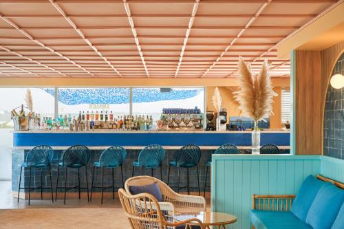 a restaurant with a blue bar with chairs at Hotel Indigo Bordeaux Centre Chartrons by IHG in Bordeaux