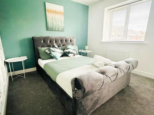 ein Schlafzimmer mit einem Bett und einem Sofa darin in der Unterkunft Maize Stylish 3 Bedroom House with Hot tub in Kingsnorth