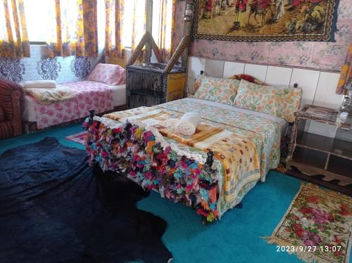 a bedroom with a bed with a quilt on it at Maison d'hotes Ait Bou Izryane in Timoulilt