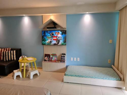 um quarto com uma cama e uma parede azul em Tabatinga Residence Flat Family Kids 04 em Conde