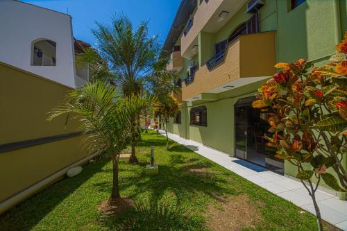 una fila de edificios con palmeras en un patio en Ubatuba Eco Hotel, en Ubatuba