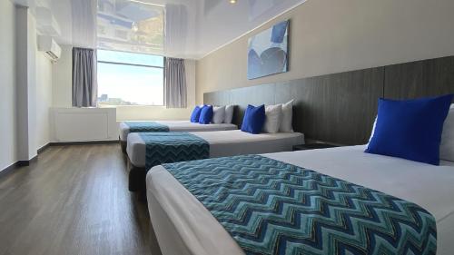 Habitación de hotel con 2 camas y almohadas azules en On Vacation Blue Tone, en San Andrés