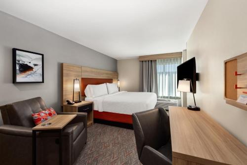 a hotel room with a bed and a desk and chair at Candlewood Suites - Layton - Salt Lake City by IHG in Layton
