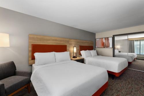 a hotel room with two beds and a chair at Candlewood Suites - Layton - Salt Lake City by IHG in Layton