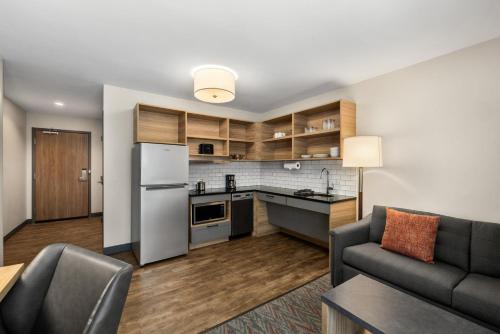 a kitchen and living room with a refrigerator and a couch at Candlewood Suites - Layton - Salt Lake City by IHG in Layton