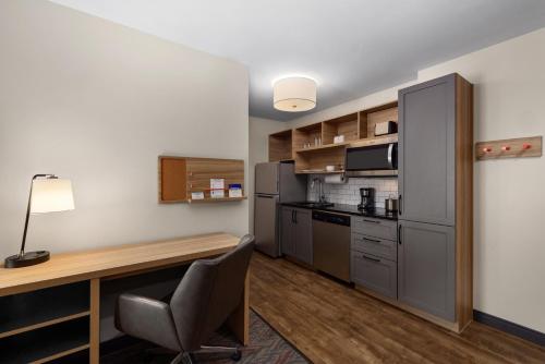 a small kitchen with a desk and a refrigerator at Candlewood Suites - Layton - Salt Lake City by IHG in Layton