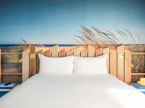 a bedroom with a bed with a view of the beach at Ibis Styles Montpellier Aéroport Parc Des Expos in Mauguio