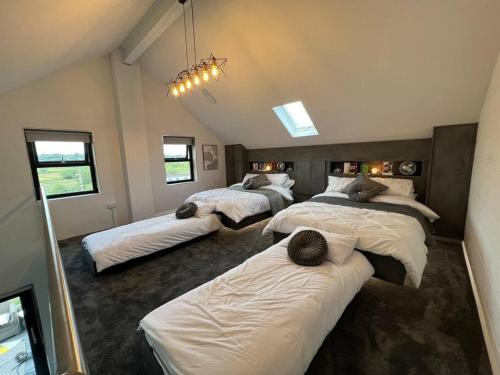 1 dormitorio con 3 camas en una habitación en Luxury hot tub & sauna apartment with pool table in the centre of northern ireland,sleeps 6 people, en Coalisland