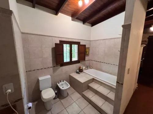 uma casa de banho com uma banheira, um WC e um lavatório. em Casa Quinta con Pileta en mercedes. 6 personas em Mercedes