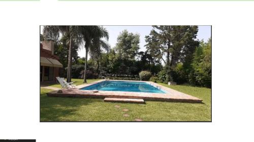uma piscina num quintal com relvado em Casa Quinta con Pileta en mercedes. 6 personas em Mercedes