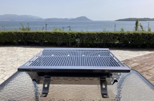 a picnic table with a view of the water at Seaside Villa SASAO in Aji