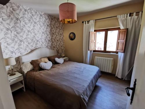 Un dormitorio con una cama grande y una ventana en Casa acogedora en la naturaleza en San Martín del Rey Aurelio