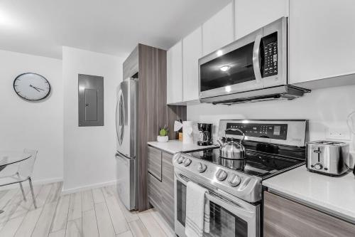 a kitchen with a stove and a microwave at Lovely Unit Mins from Wynwood with Free Parking in Miami
