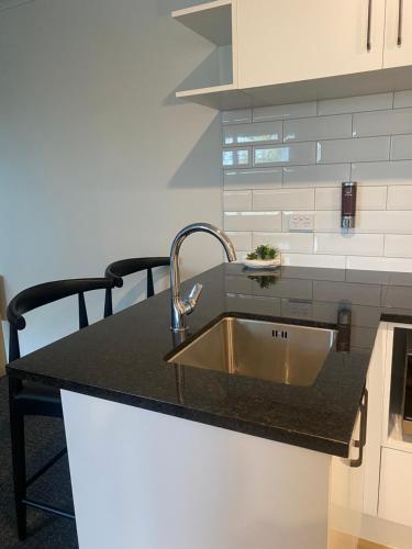 a kitchen with a sink and a black counter top at Norton Motel in Hamilton