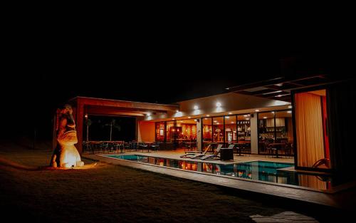 カピトーリオにあるPousada Quinta dos Cabeçasの夜の建物前に立つ女