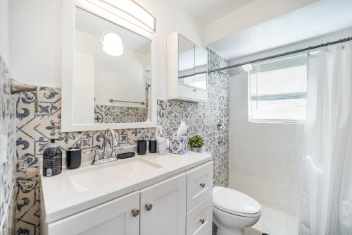 a white bathroom with a sink and a toilet at Dior Lake Front Villa With Infinity Pool & Hot Tub in Miami Gardens
