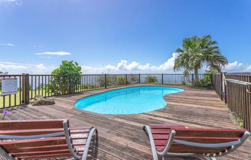 una piscina en una terraza de madera con 2 sillas en L'îlot Fruits Guadeloupe en Trois-Rivières