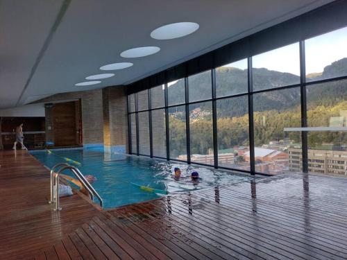 a large swimming pool in a building with a large window at Nuevo! Apartamento Oasis Central in Bogotá