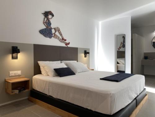 een slaapkamer met een bed met een vrouw aan de muur bij Hôtel Lune de Miel in Deshaies