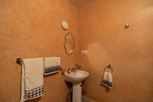 a bathroom with a sink and a toilet and towels at Riad Qamar Fez in Fès