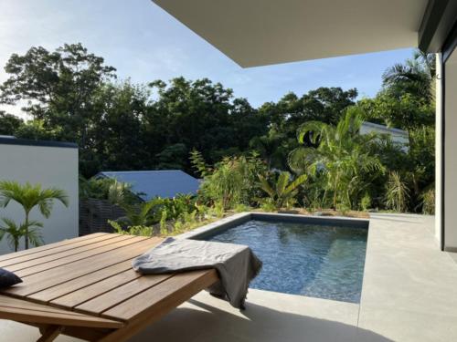 a swimming pool with a wooden deck next to a swimming pool at Hôtel Lune de Miel in Deshaies