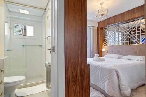 a bedroom with a king sized bed and a shower at Vita Boulevard Luxo 2 Suítes by Achei Gramado in Gramado