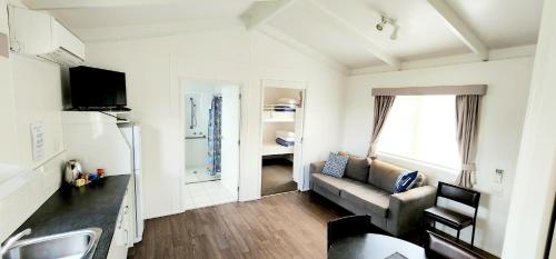ein Wohnzimmer mit einem Sofa und einer Küche in der Unterkunft Spicer Caravan Park in Parkes