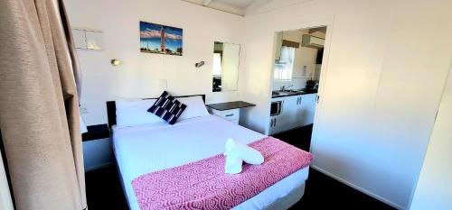 a bedroom with a bed with a teddy bear on it at Spicer Caravan Park in Parkes