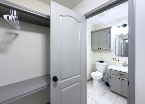 a white bathroom with a toilet and a sink at Chic, Quiet 2BR 2BA Near Shops & Restos! in McAllen