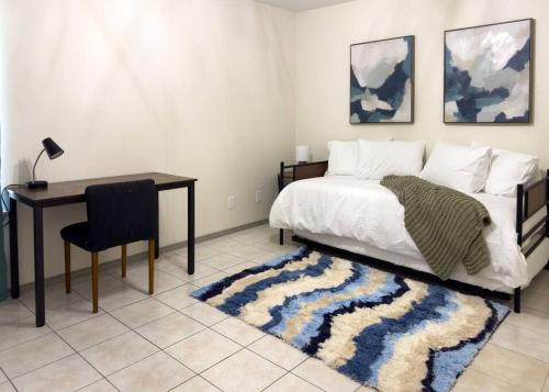 a bedroom with a bed and a desk and a table at Chic, Quiet 2BR 2BA Near Shops & Restos! in McAllen