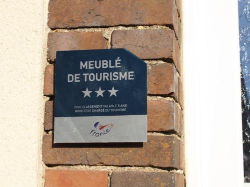 a sign on the side of a brick wall at Gîte chaleureux avec jardin arboré, terrasse, salle de jeux et parking privé à Pré-Saint-Évroult. - FR-1-581-3 in Pré-Saint-Évroult