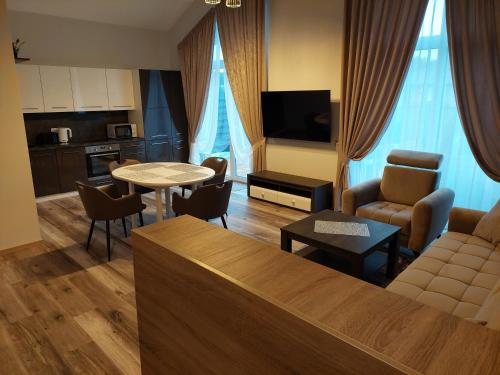 a living room with a couch and a table with chairs at Sweet villa Palanga in Palanga