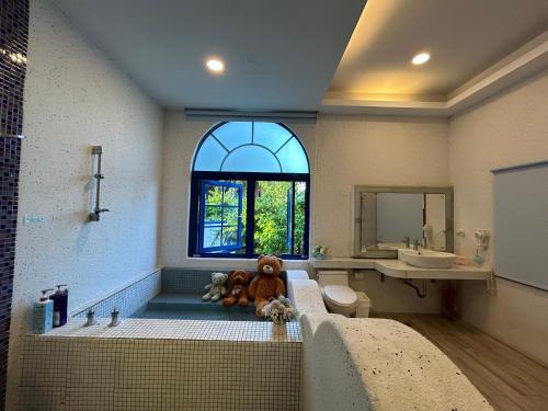 ein Badezimmer mit einer Badewanne mit einem Teddybär in der Unterkunft 太平洋渡假村 in Fengbin